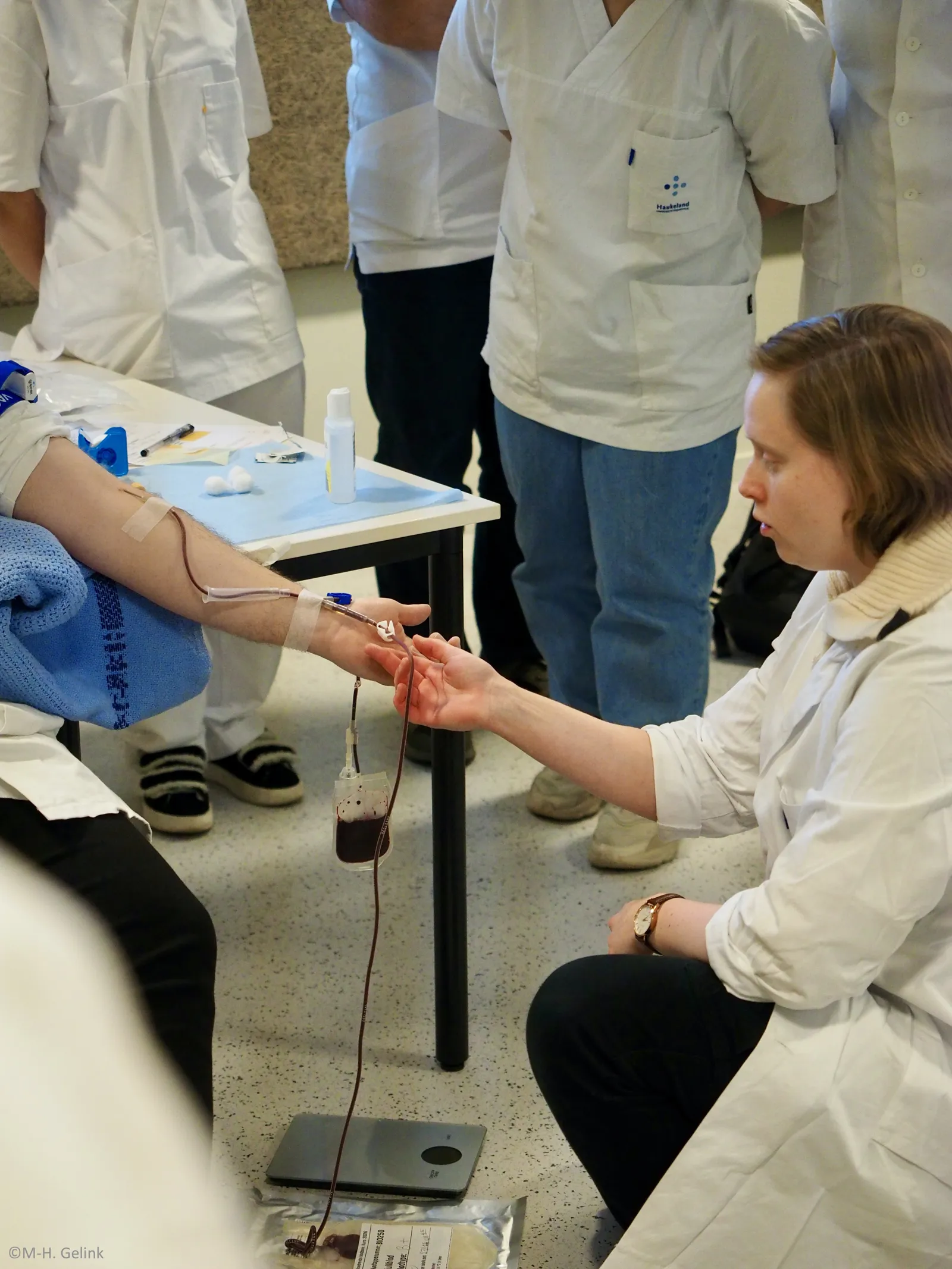 En gruppe mennesker i hvite laboratoriefrakker som jobber med et laboratorieeksperiment