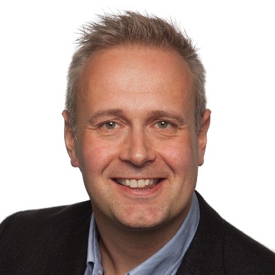 En mann som smiler til kameraet