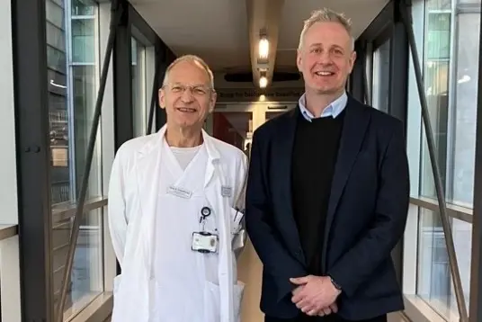 En mann og en kvinne som står i et rom med glassdører