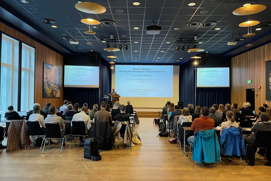 A group of people sitting in a room with a projector screen