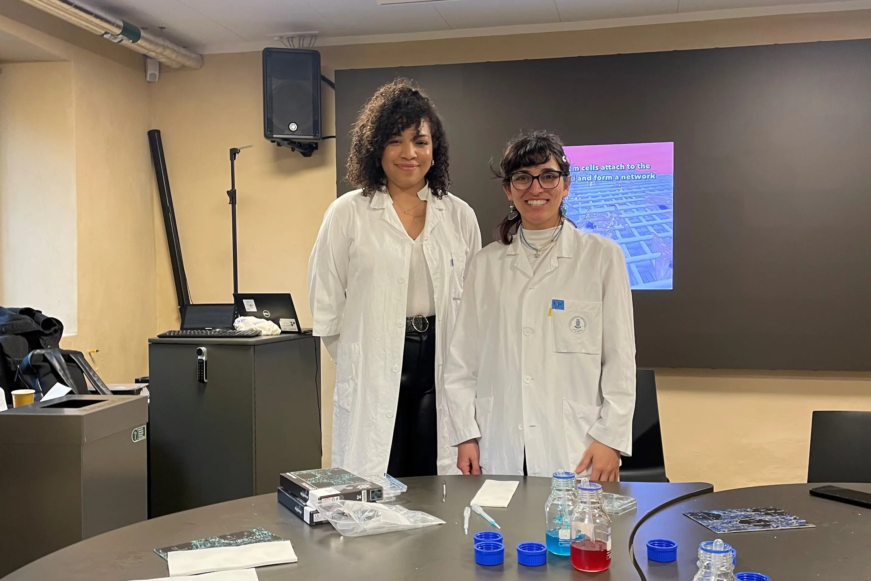 A couple of women in white coats has lab demonstration