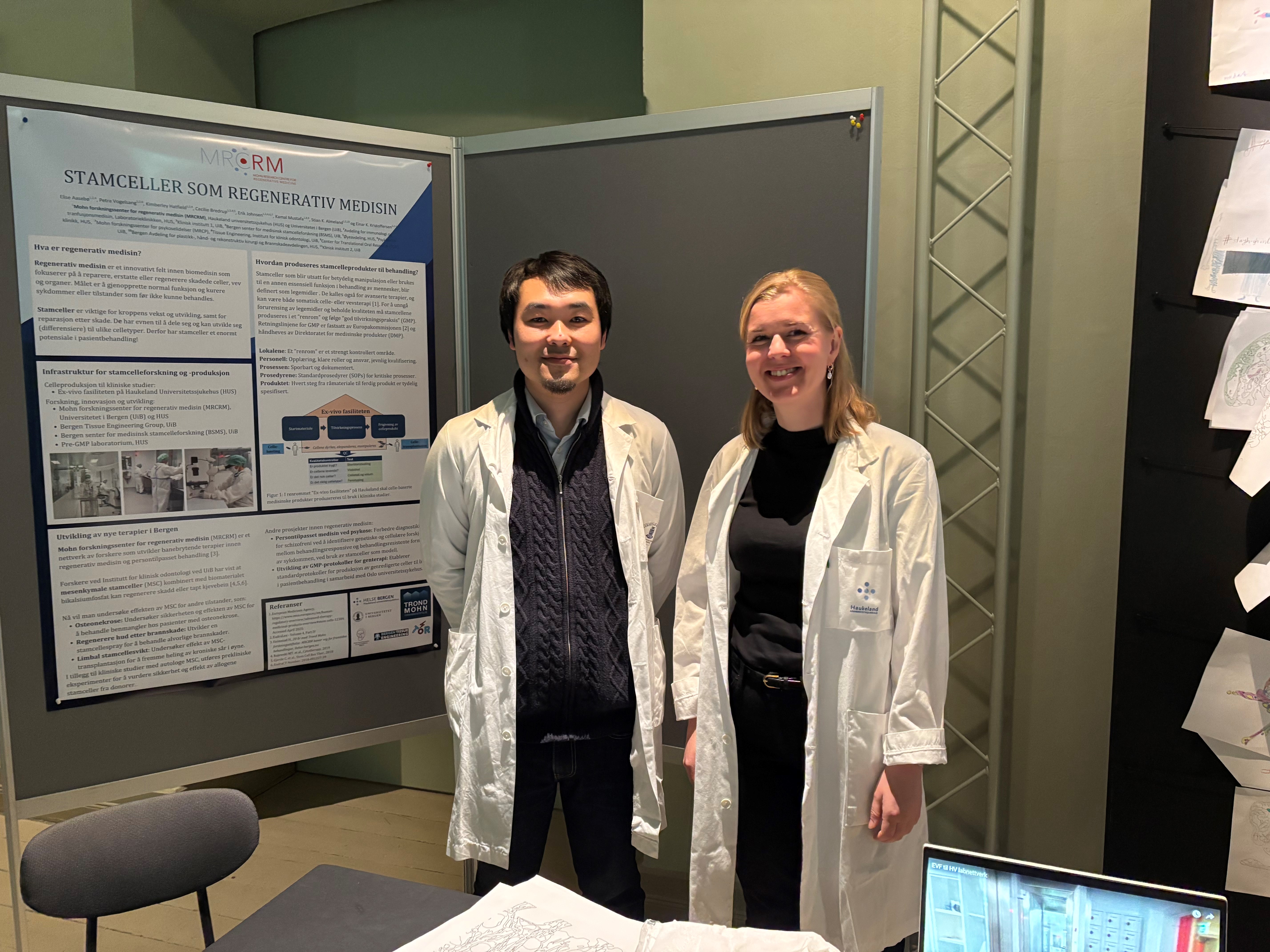 A man and a woman standing next to a poster