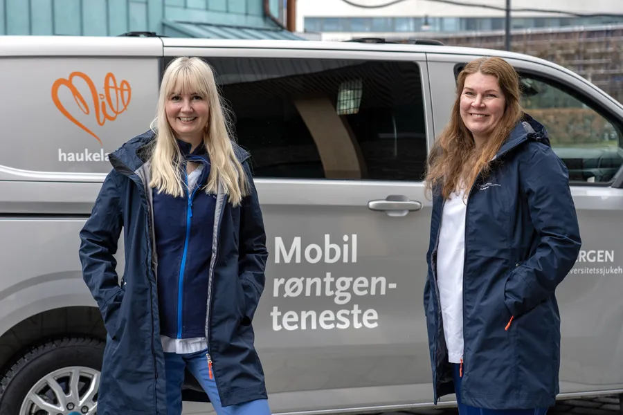 Two women standing in front of a van