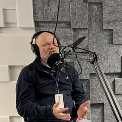 En mann som sitter i et studio med headset og mikrofon