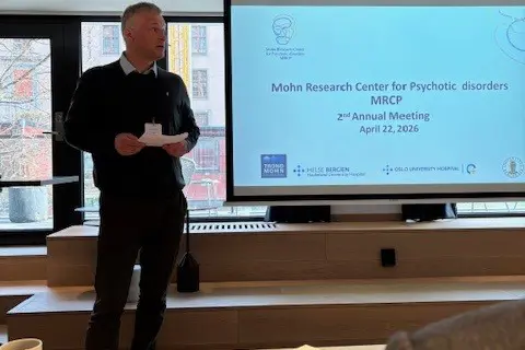 A man standing in front of a projector screen