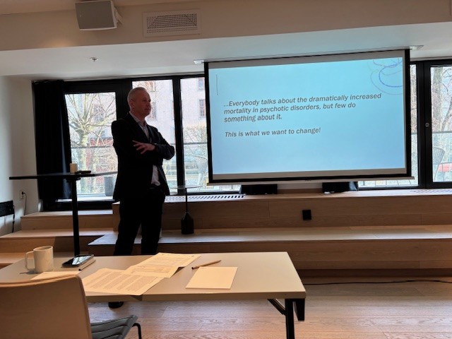 En mann som står foran en projektorskjerm