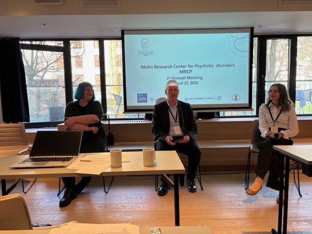 En gruppe mennesker som sitter foran en projektorskjerm