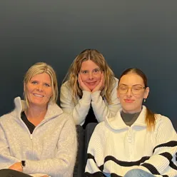 En gruppe kvinner som sitter sammen og smiler