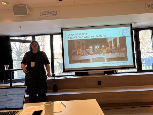 En kvinne som står foran en stor skjerm