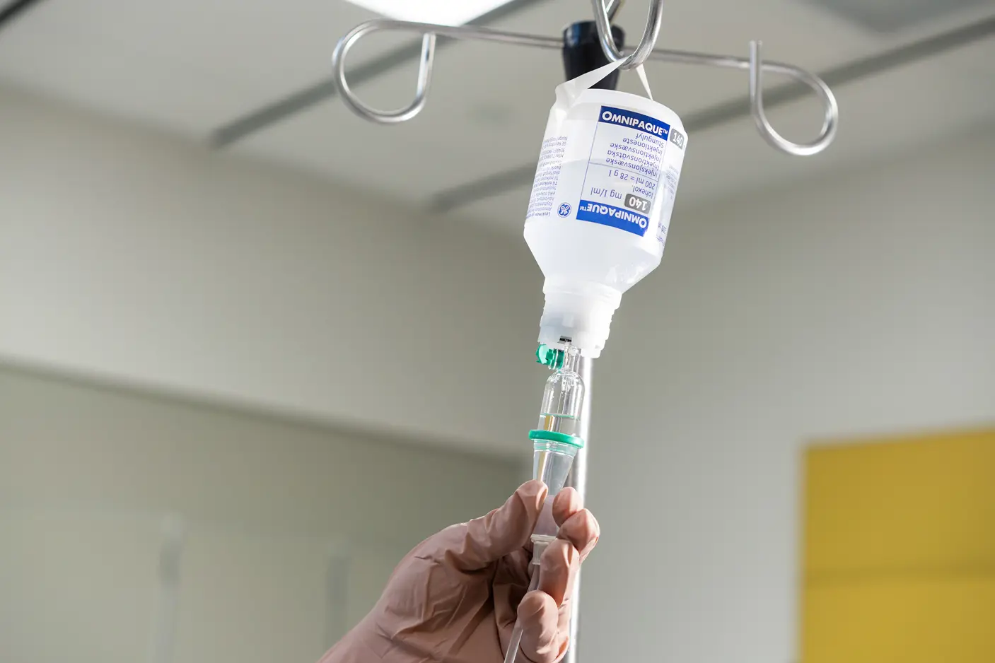 En hånd og et stativ som det henger en pose væske på