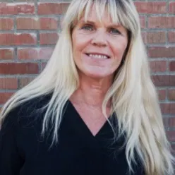 En kvinne som smiler til kameraet