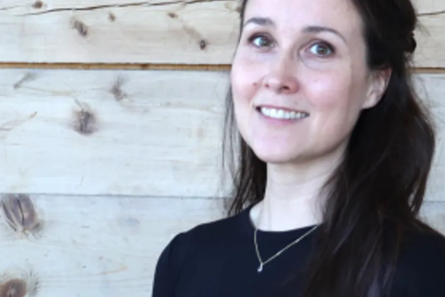 En kvinne som smiler til kameraet
