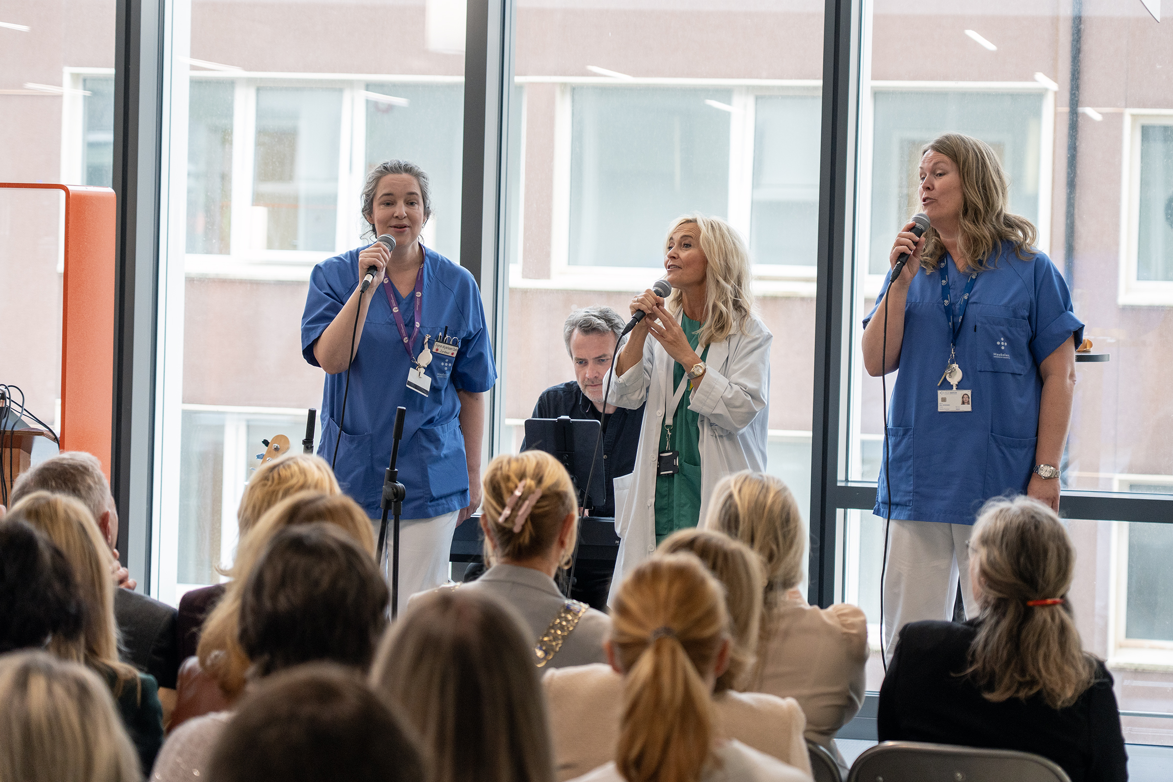 En gruppe mennesker som synger foran en folkemengde