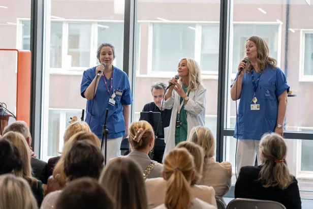 En gruppe mennesker som synger foran en folkemengde