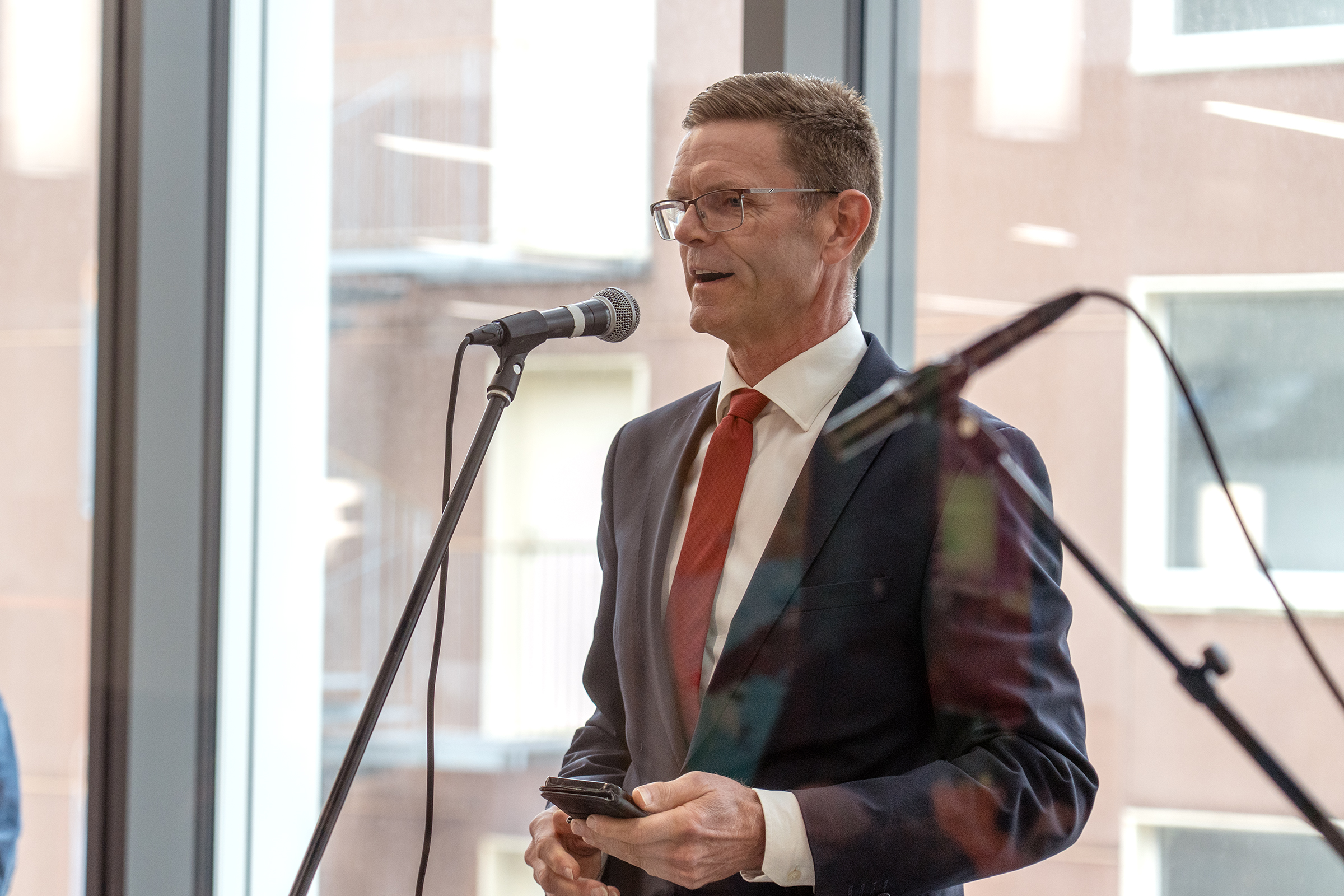 En mann i dress som snakker i en mikrofon