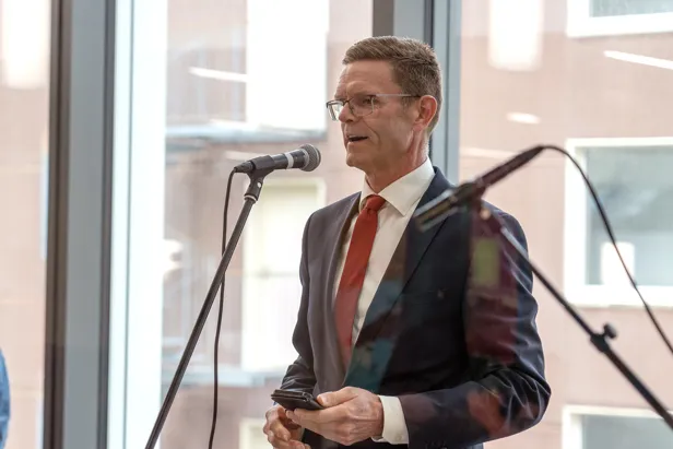 En mann i dress som snakker i en mikrofon