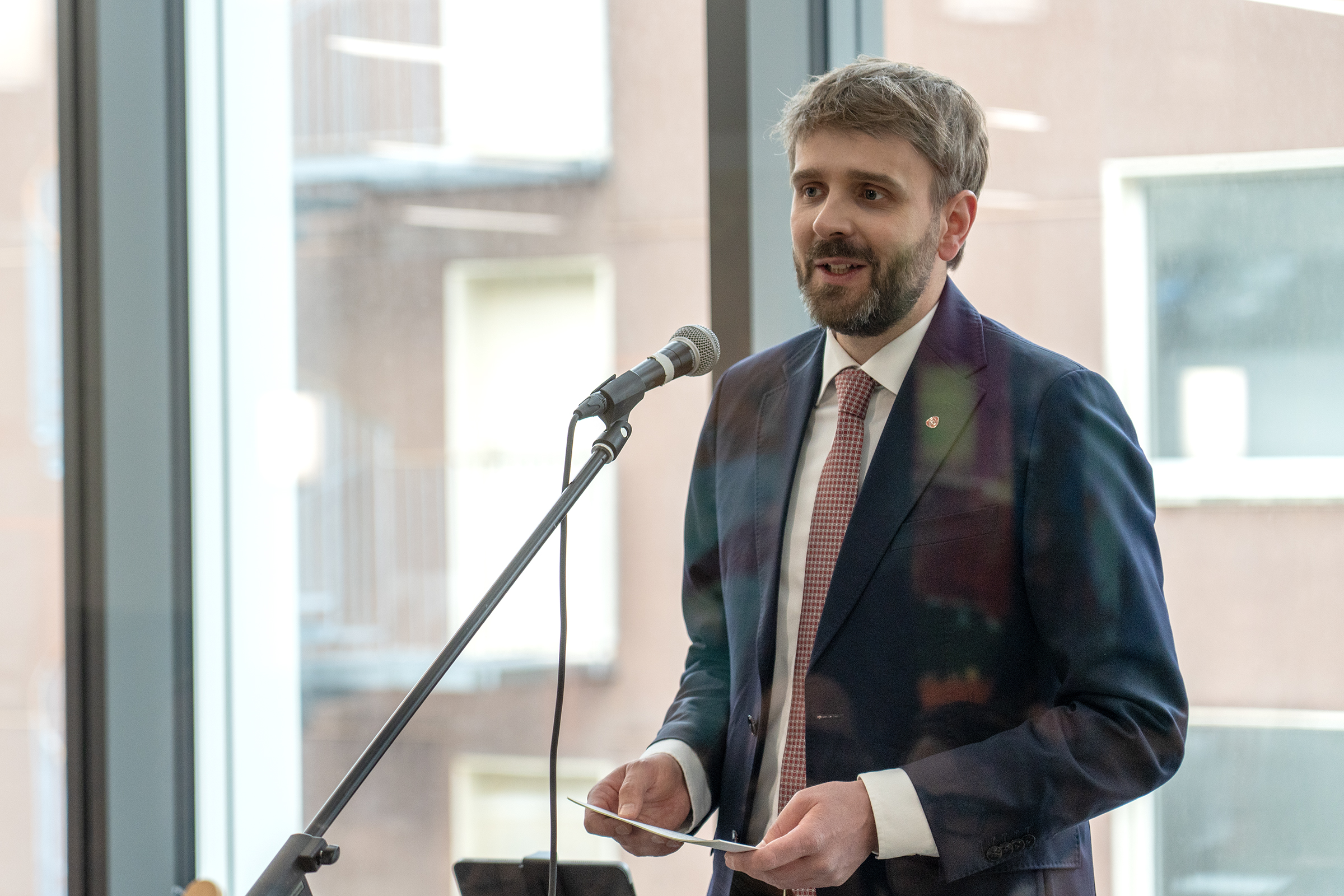 En mann i dress som snakker i en mikrofon