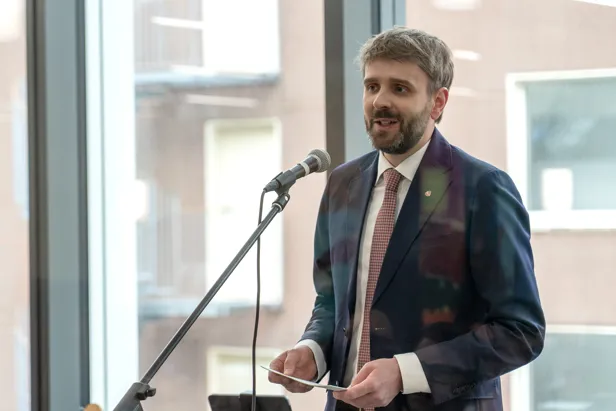 En mann i dress som snakker i en mikrofon