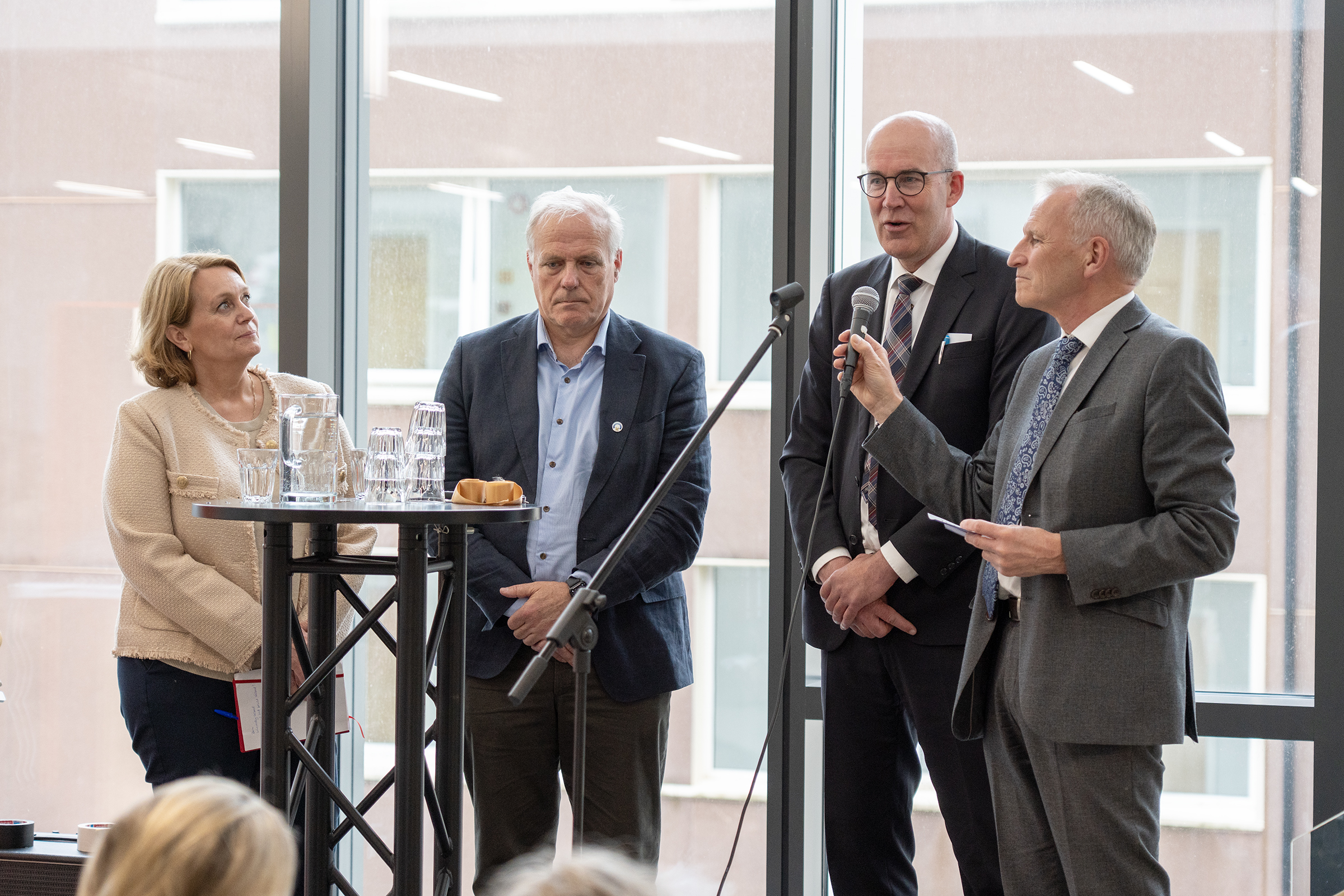 En gruppe mennesker som står på et podium og snakker