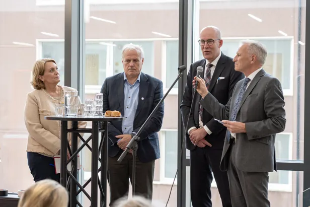 En gruppe mennesker som står på et podium og snakker