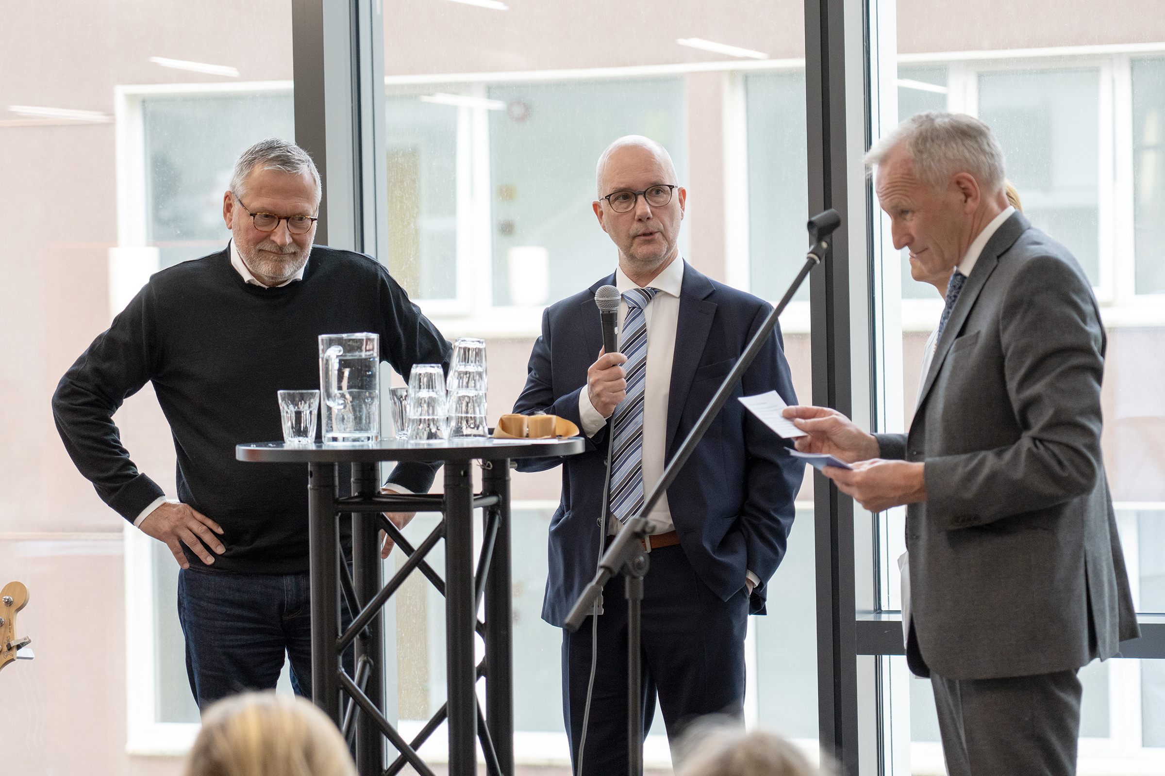 Tre menn som snakker sammen