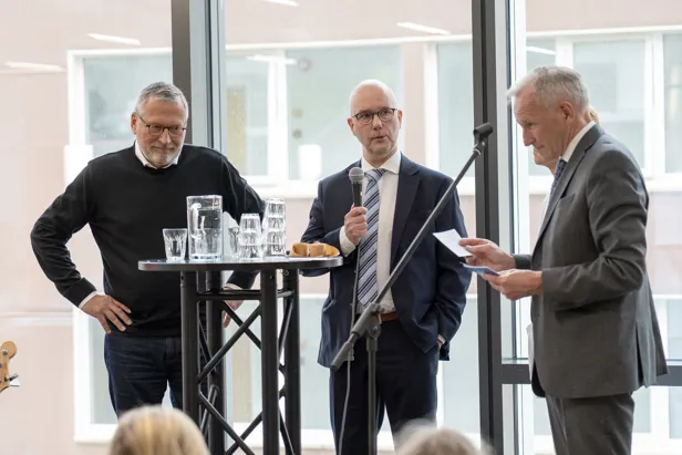 Tre menn som snakker sammen