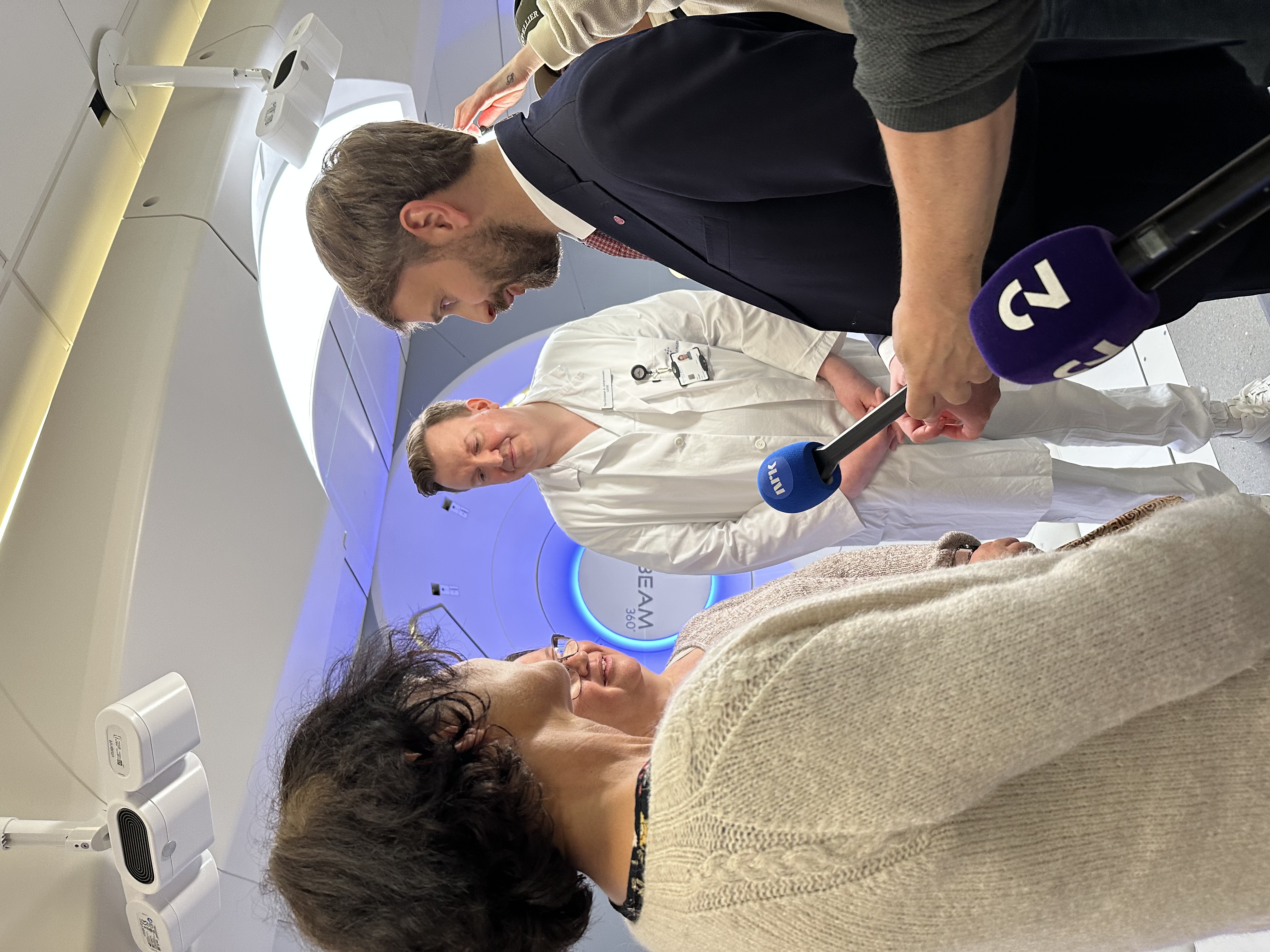 En mann som snakker med en kvinne og flere journalister