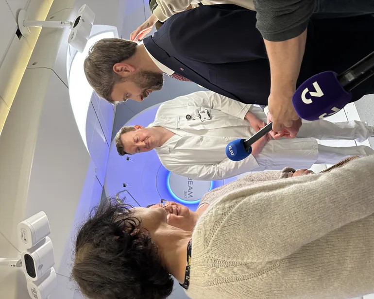 En mann som snakker med en kvinne og flere journalister