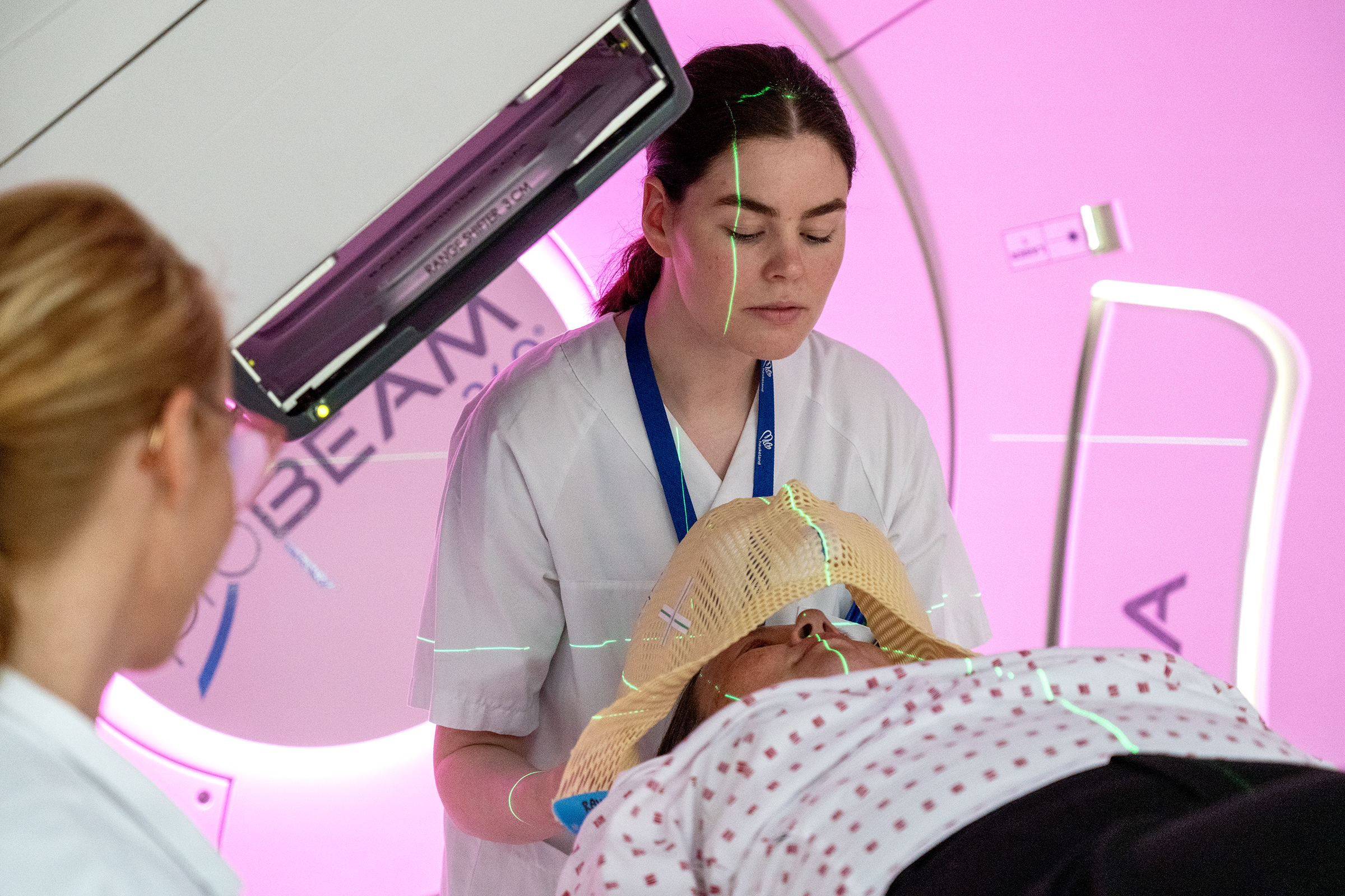 En sykepleier holder fast en maske på en pasient