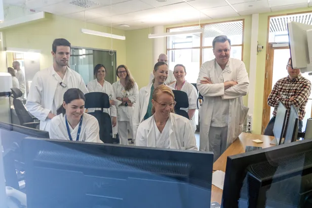 En gruppe mennesker som ser på flere skjermer