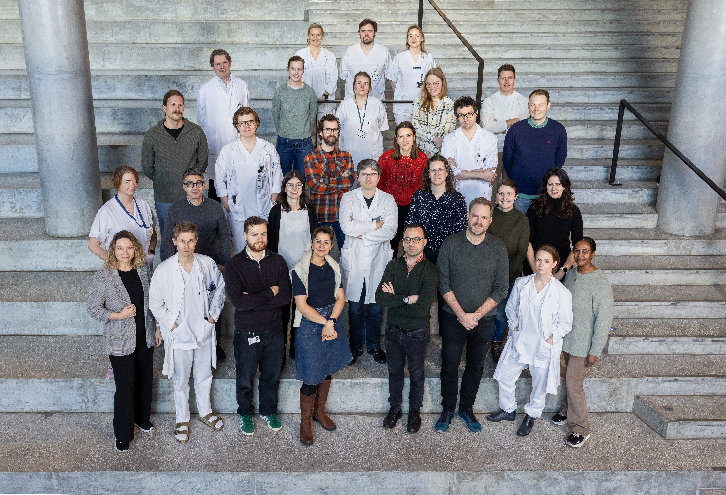 En gruppe mennesker som poserer for et bilde i trapper