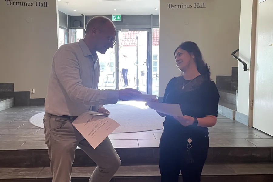 A man and woman standing next to each other and looking at a paper