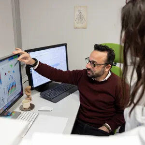 En mann og kvinne som ser på en dataskjerm med tabeller