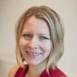 En kvinne som smiler til kameraet