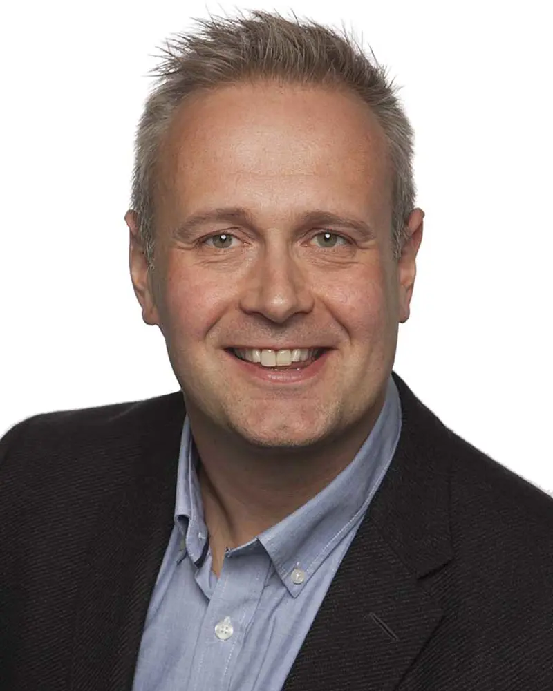 En mann som smiler til kameraet