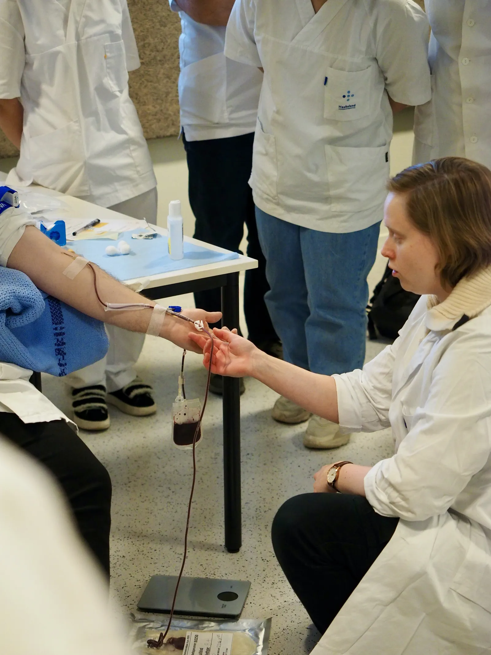 A group of people in white lab coats working on a table