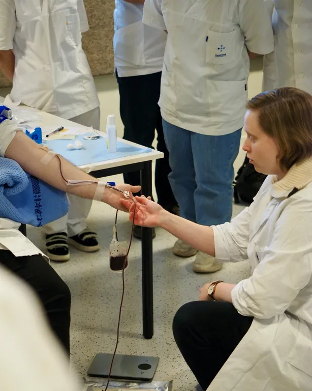 A group of people in white lab coats working on a table