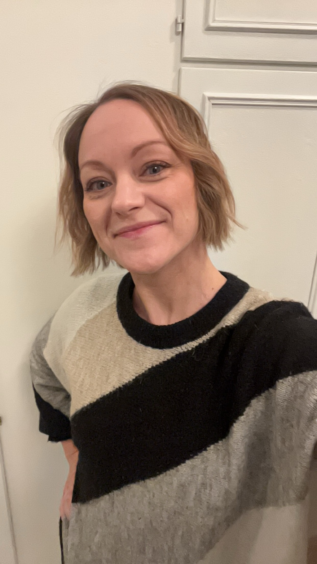 En kvinne som smiler til kameraet