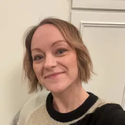 En kvinne som smiler til kameraet