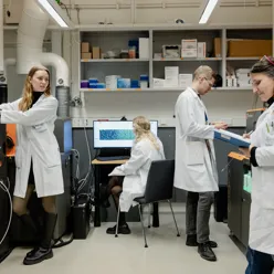 En gruppe mennesker i laboratoriefrakker