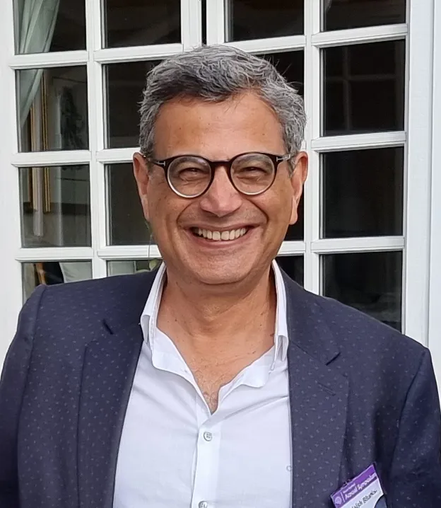 A man wearing glasses, smiling at the camera