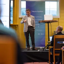 Xavier Montalban står foran eit podium med ein mikrofon med publikum foran seg
