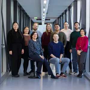 En gruppe med ti personer som poserer for kamera.