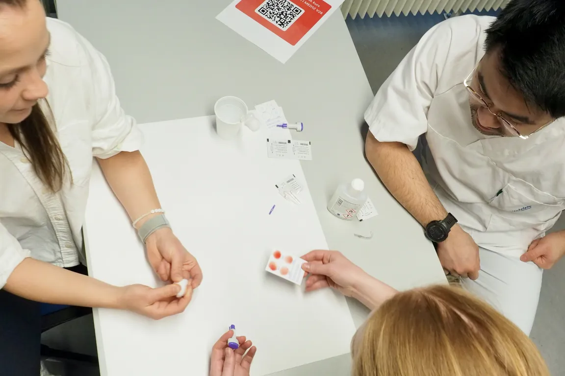 A group of people looking at a white board with a red and white sign