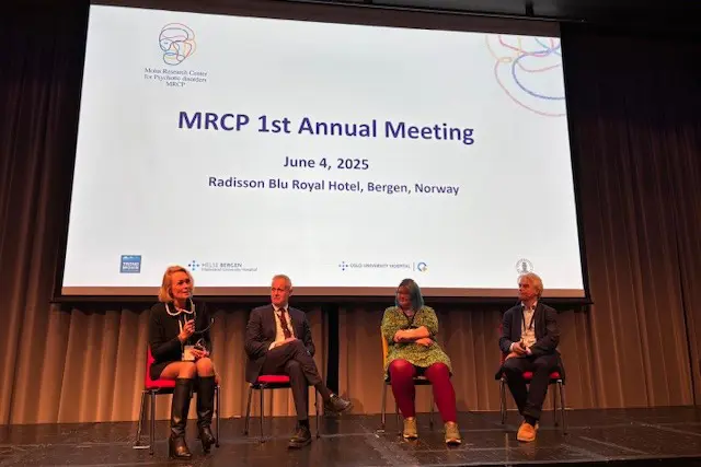 A group of people sitting on chairs in front of a projector screen