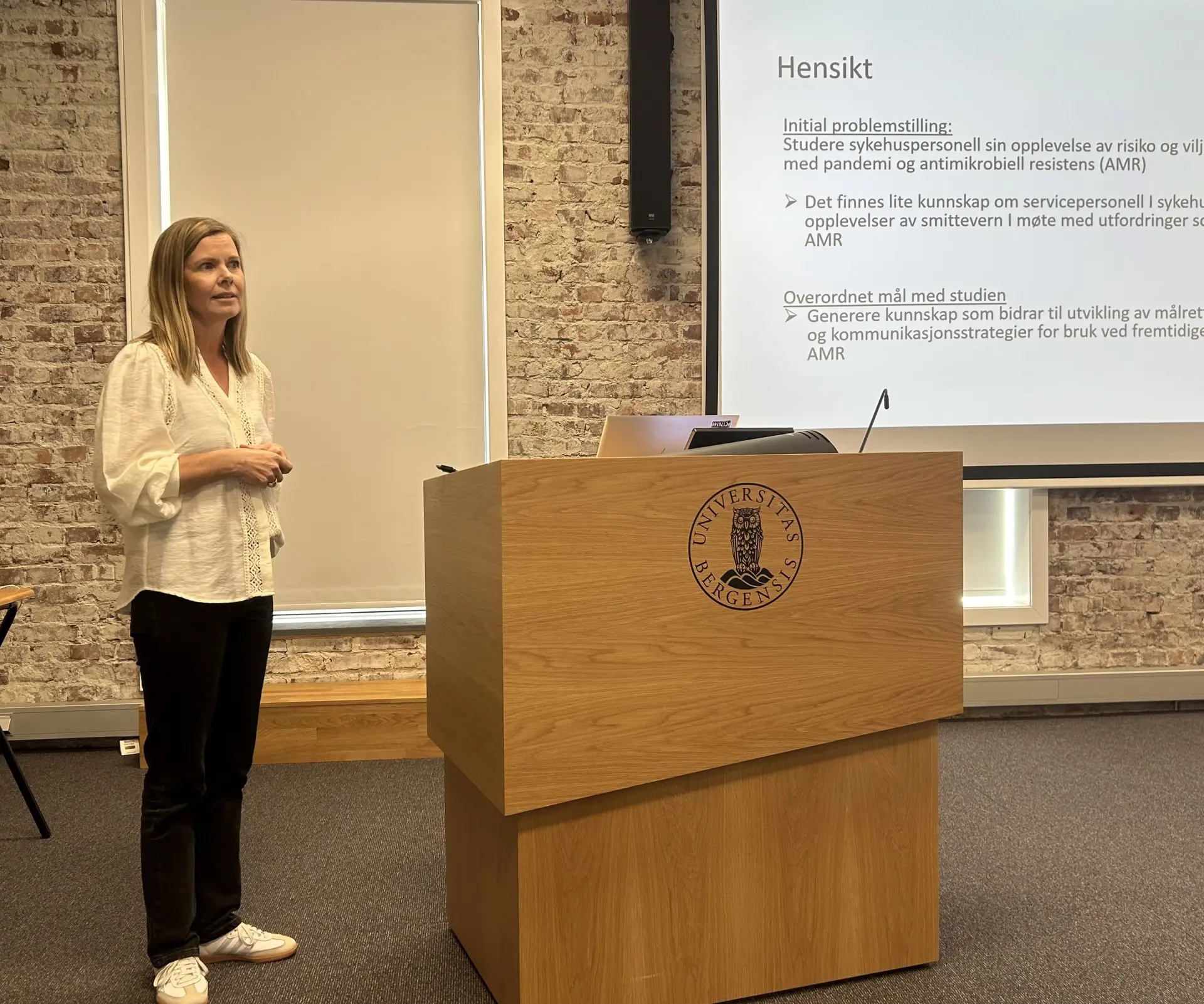 En kvinne som står ved siden av et podium