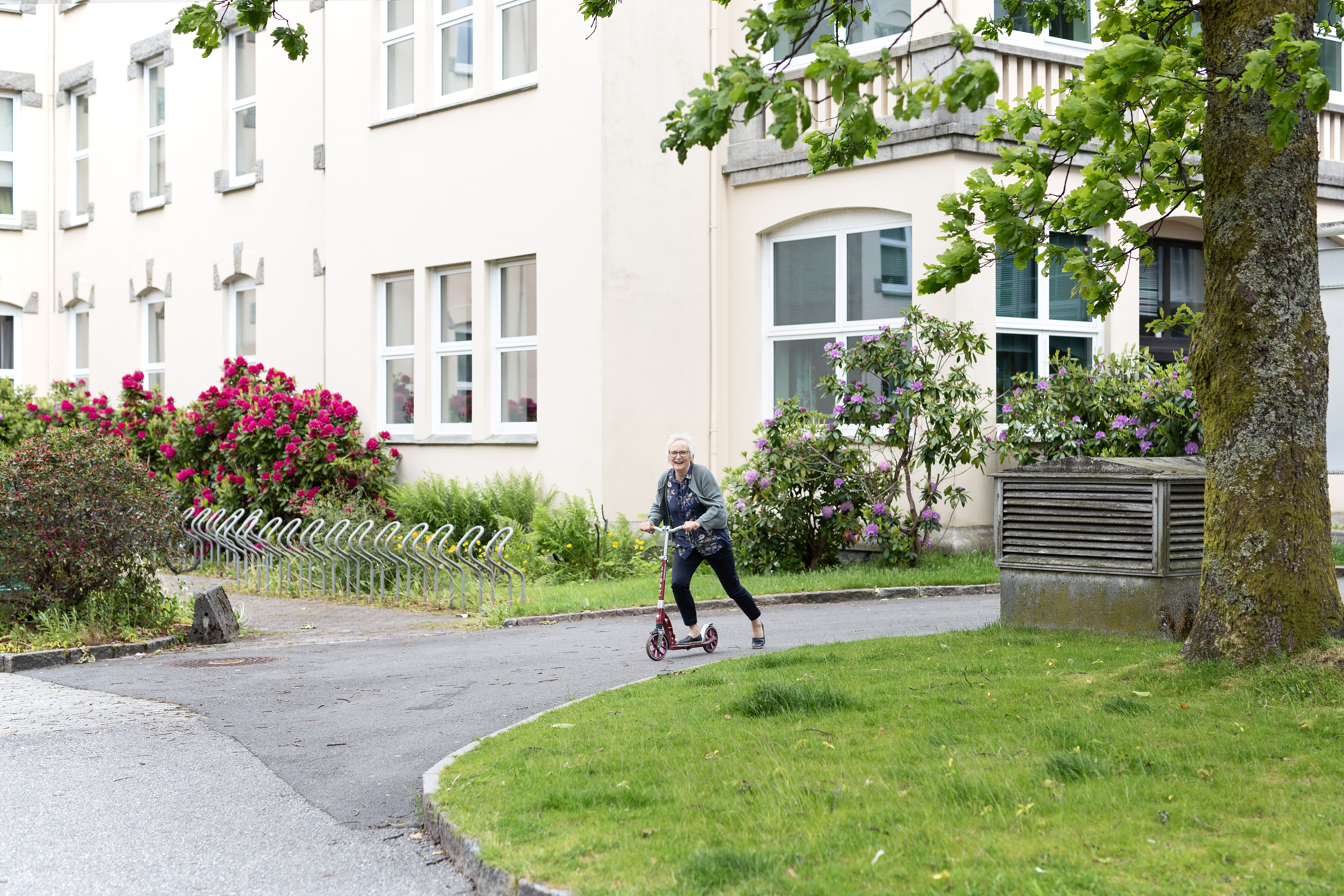 kvinne på sparkesykkel i en park