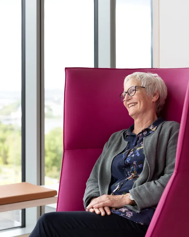 Smilende kvinne i en stol