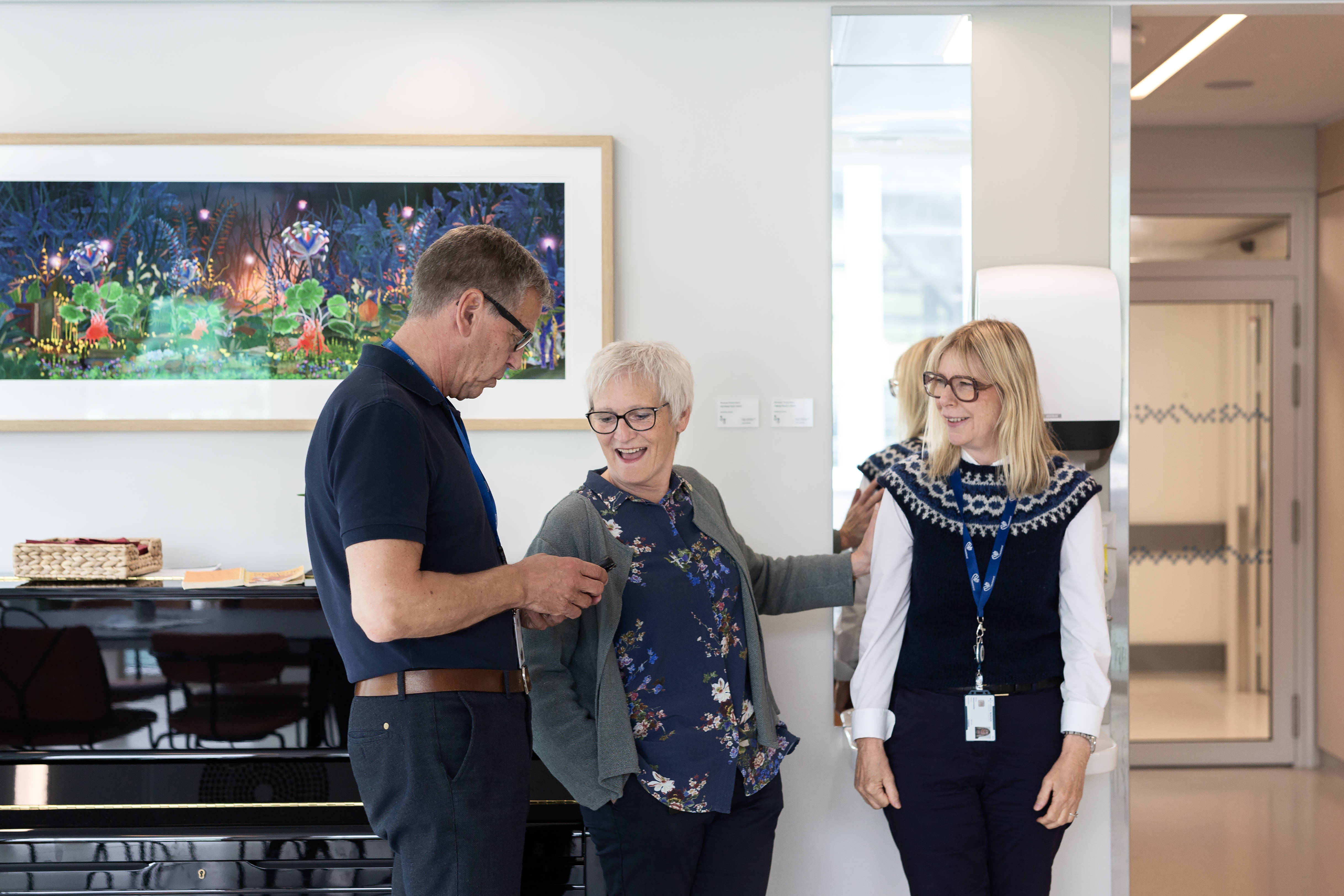 to kvinner og en mann står og snakker sammen