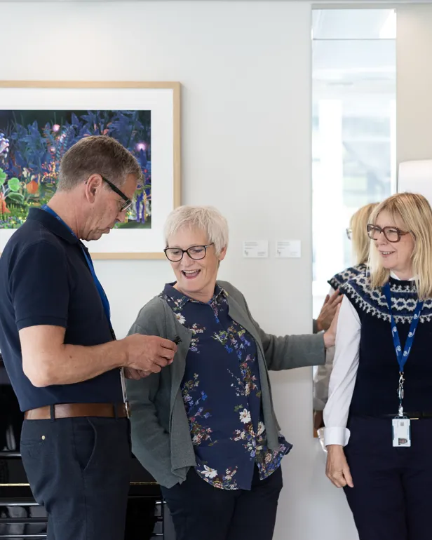 to kvinner og en mann står og snakker sammen